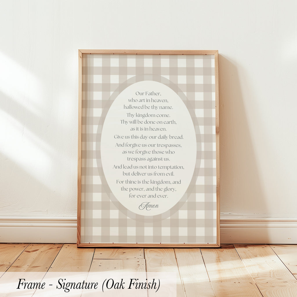 a framed print with a religious text, specifically a prayer or Bible verse, displayed on a wooden floor against a white wall.