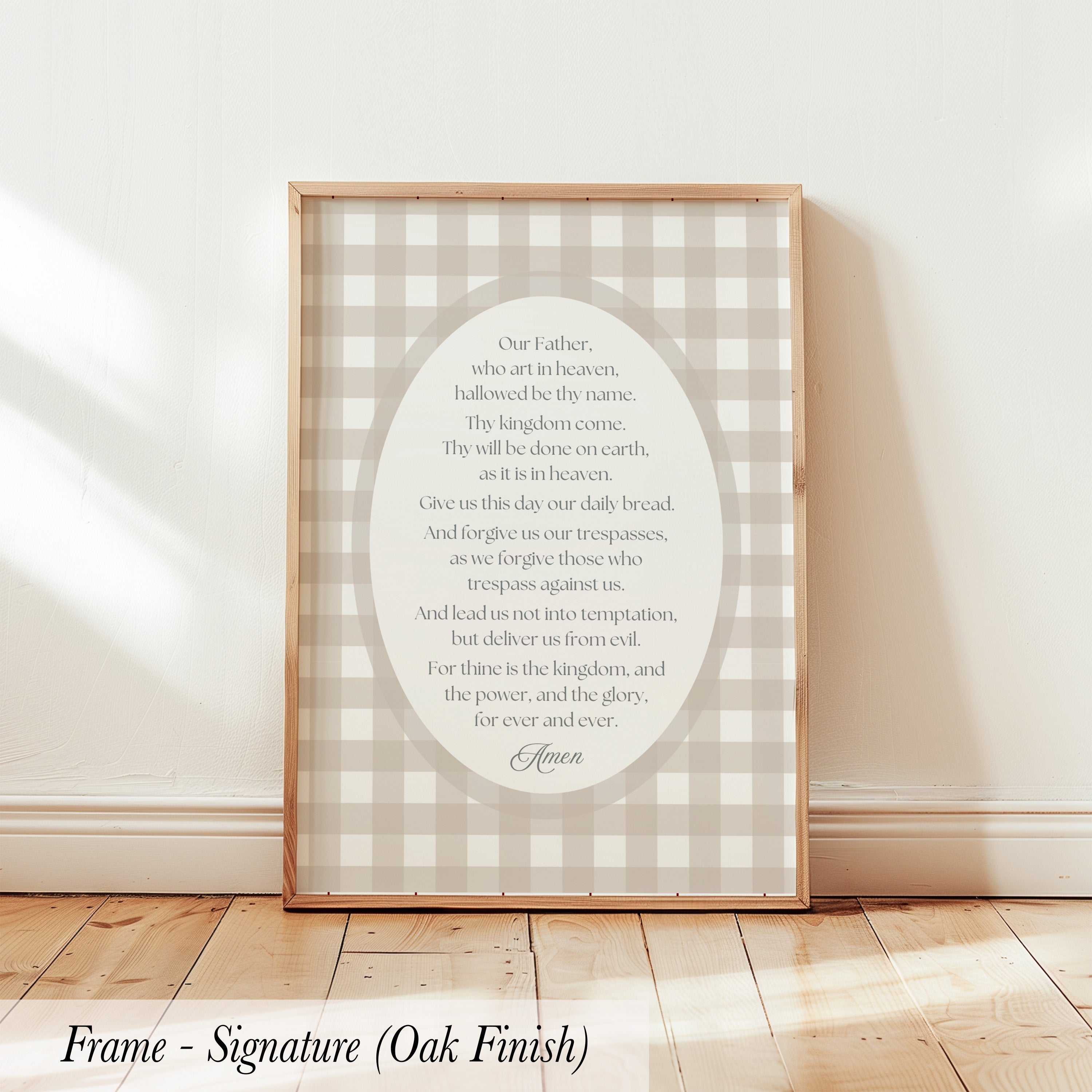 a framed print with a religious text, specifically a prayer or Bible verse, displayed on a wooden floor against a white wall.