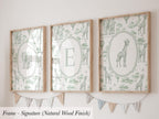 three framed artworks with a giraffe and other wildlife motifs, displayed on a wall.