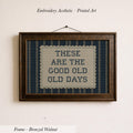 The image is a framed embroidered piece of art with the text "These are the good old days" printed on it.