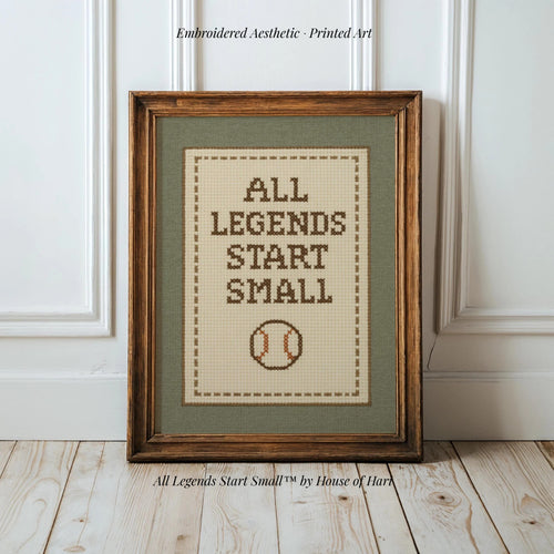 A framed cross-stitch design with the text "ALL LEGENDS START SMALL" and a baseball motif.