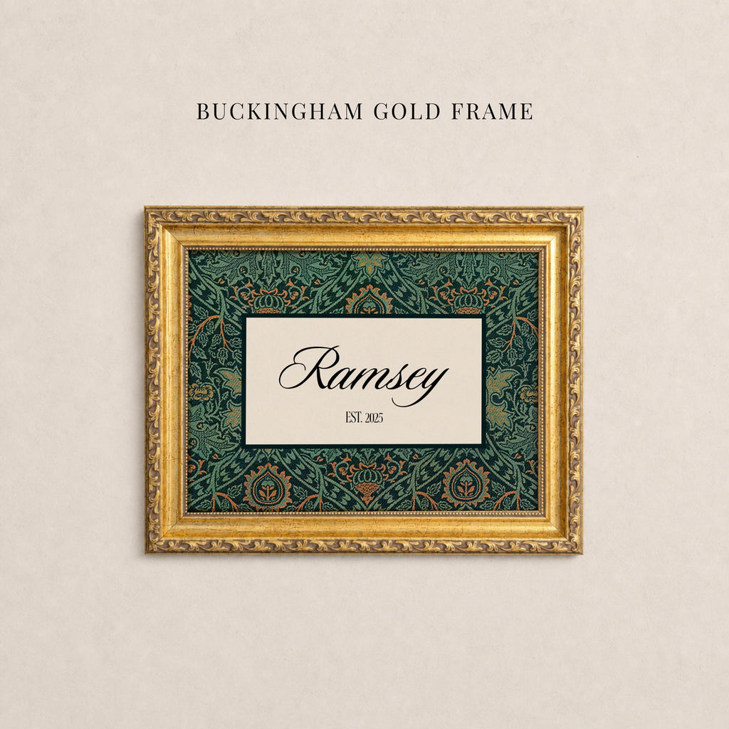 May include: A rectangular gold frame with ornate detailing surrounding a central cream-colored rectangular insert. The insert features a dark green and orange floral pattern border with the text Ramsey and EST. 2025 in black script and serif font.