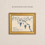 The image is a framed print of a blue and white illustration of a vine with grapes hanging from it, mounted on a wall.