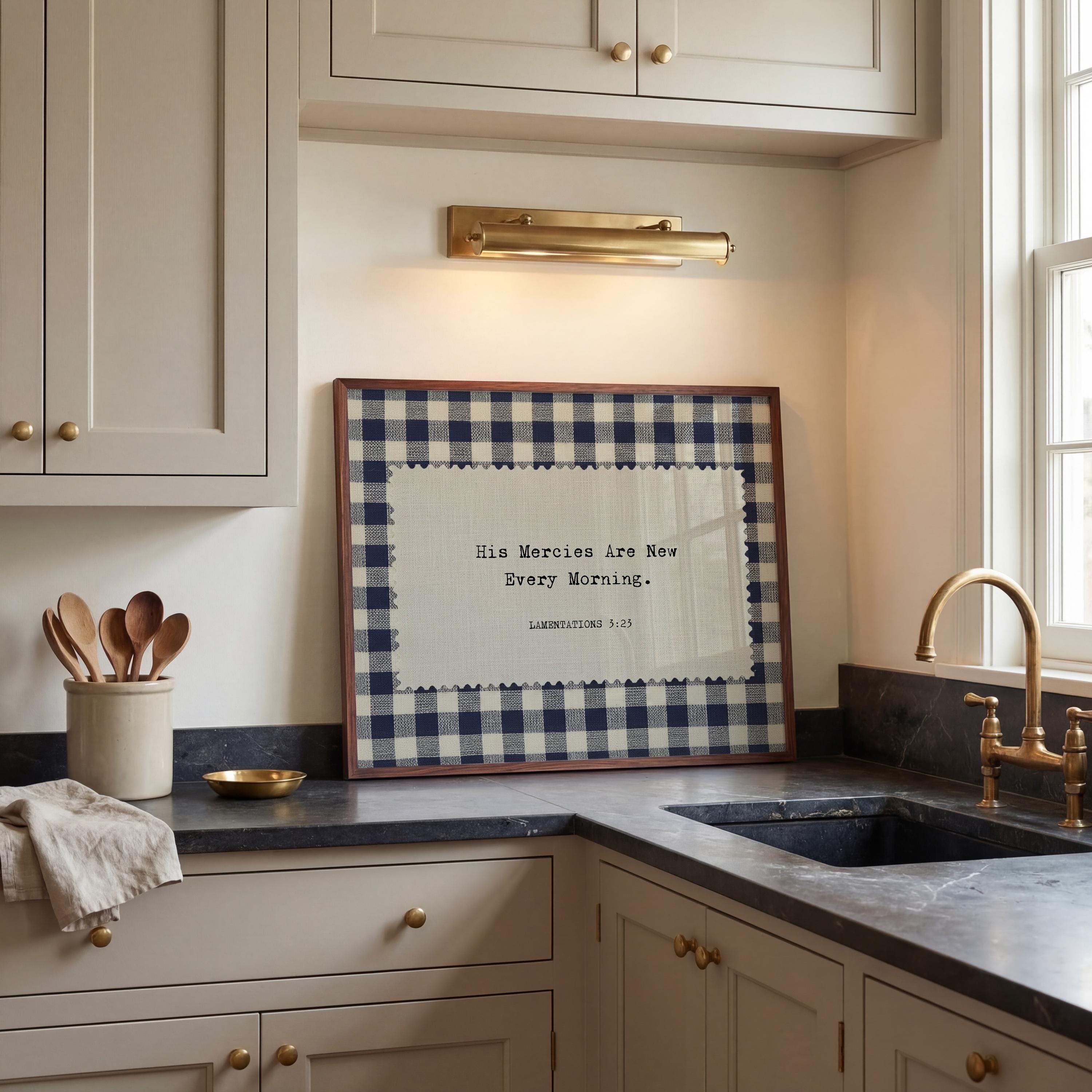 a kitchen counter with a framed quote, a sink, and various kitchen utensils such as spoons.