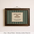 A framed embroidered art piece with the text "LITTLE BOY BIG DREAMS" on it, hanging on a wall.