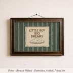 A framed embroidered art piece with the text "LITTLE BOY BIG DREAMS" on it, hanging on a wall.