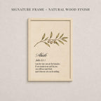 a framed print with a natural wood finish, displaying a branch with leaves and two small fruits. The text within the frame provides a definition or explanation of the word "Alike".