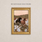 A painting of three horses running through a field of flowers, framed in a gold frame.