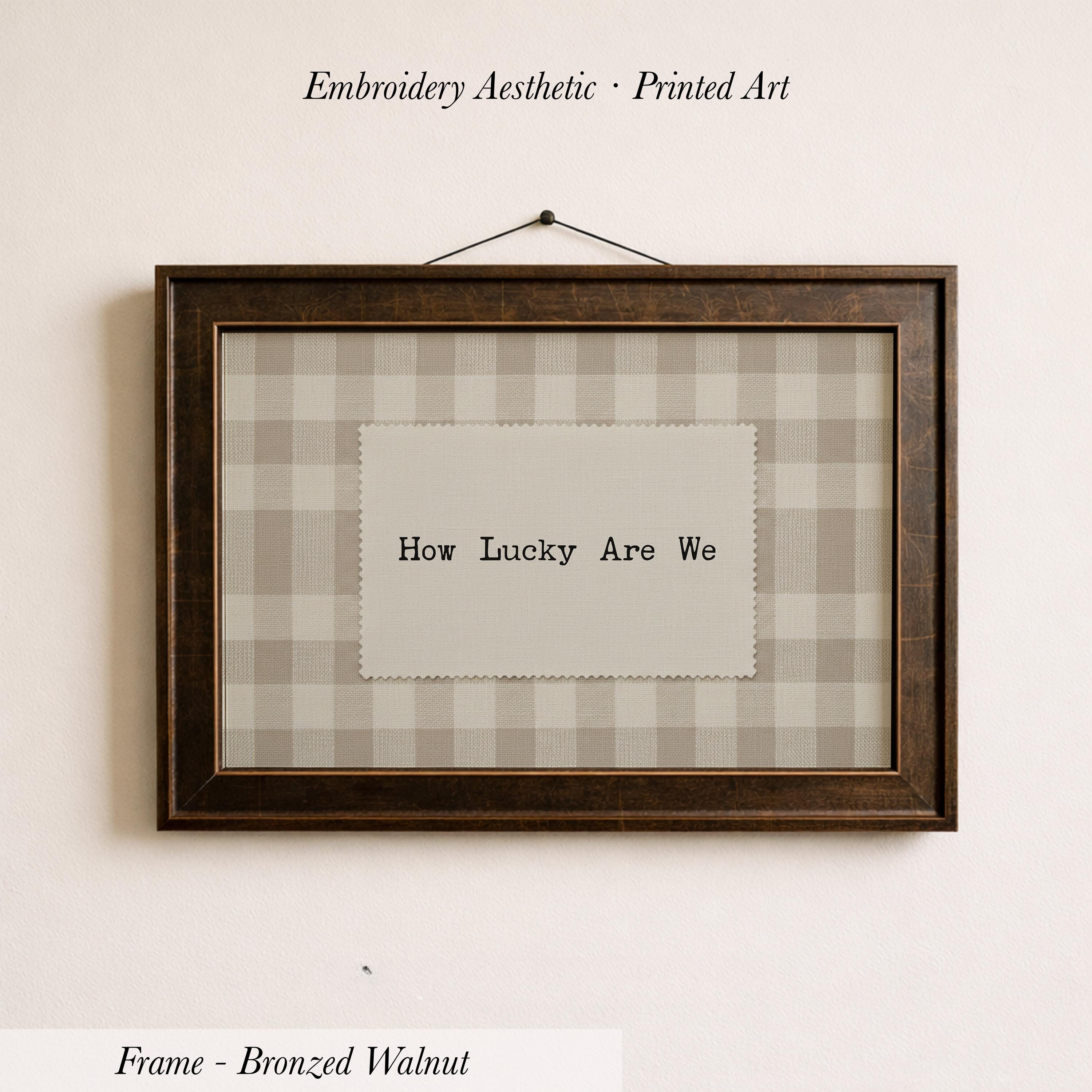 The image is a framed print with the text "How Lucky Are We" displayed on it.