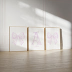 three framed pictures of bows on a wall, with the middle picture having a large bow and the other two having smaller bows.