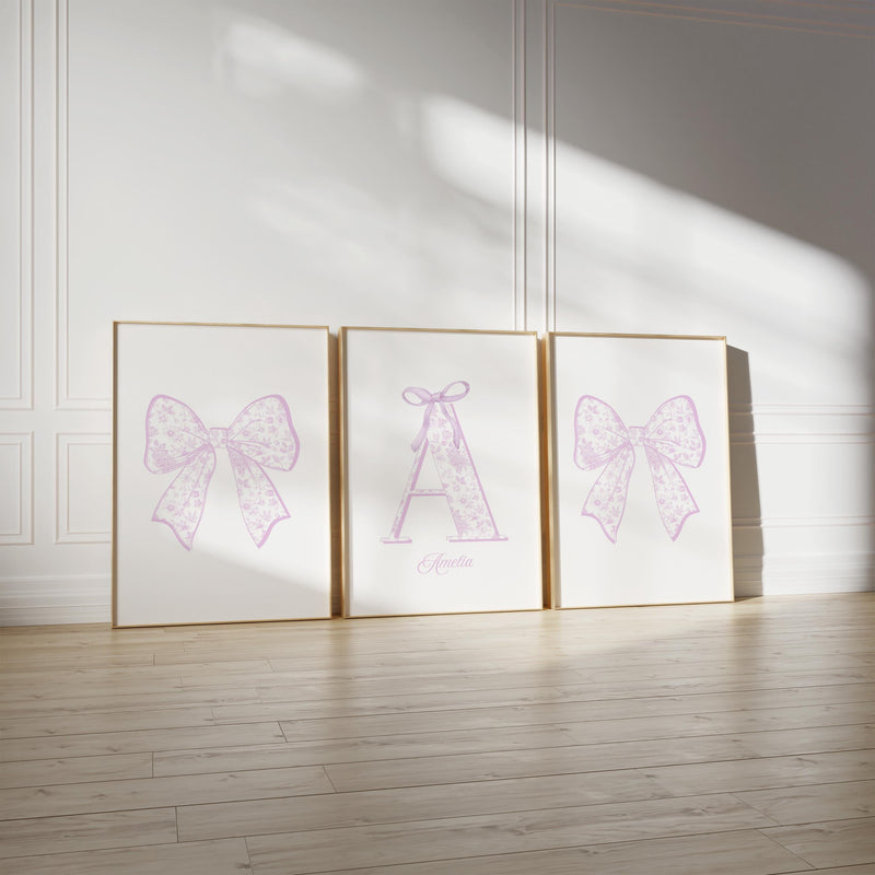 three framed pictures of bows on a wall, with the middle picture having a large bow and the other two having smaller bows.