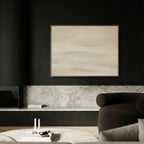 a modern living room with a black and white color scheme. The focal point is a large abstract painting hanging on the wall above a black sofa. The sofa is positioned in front of a white coffee table, which has a few candles on it. The room also includes a fireplace and a bookshelf, creating a cozy and stylish atmosphere.