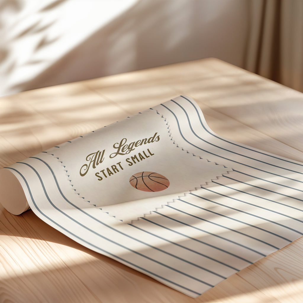 A rolled-up piece of paper with the text "All Legends Start Small" printed on it, along with a basketball graphic.