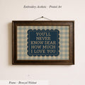 a framed print with the text "YOU'LL NEVER KNOW DEAR HOW MUCH I LOVE YOU" displayed on it.