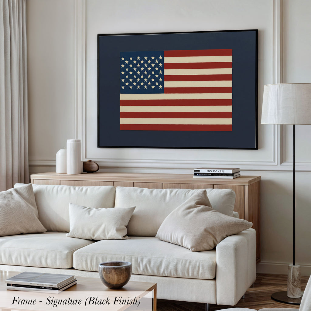 a living room with a large framed picture of the American flag hanging on the wall above a white sofa.