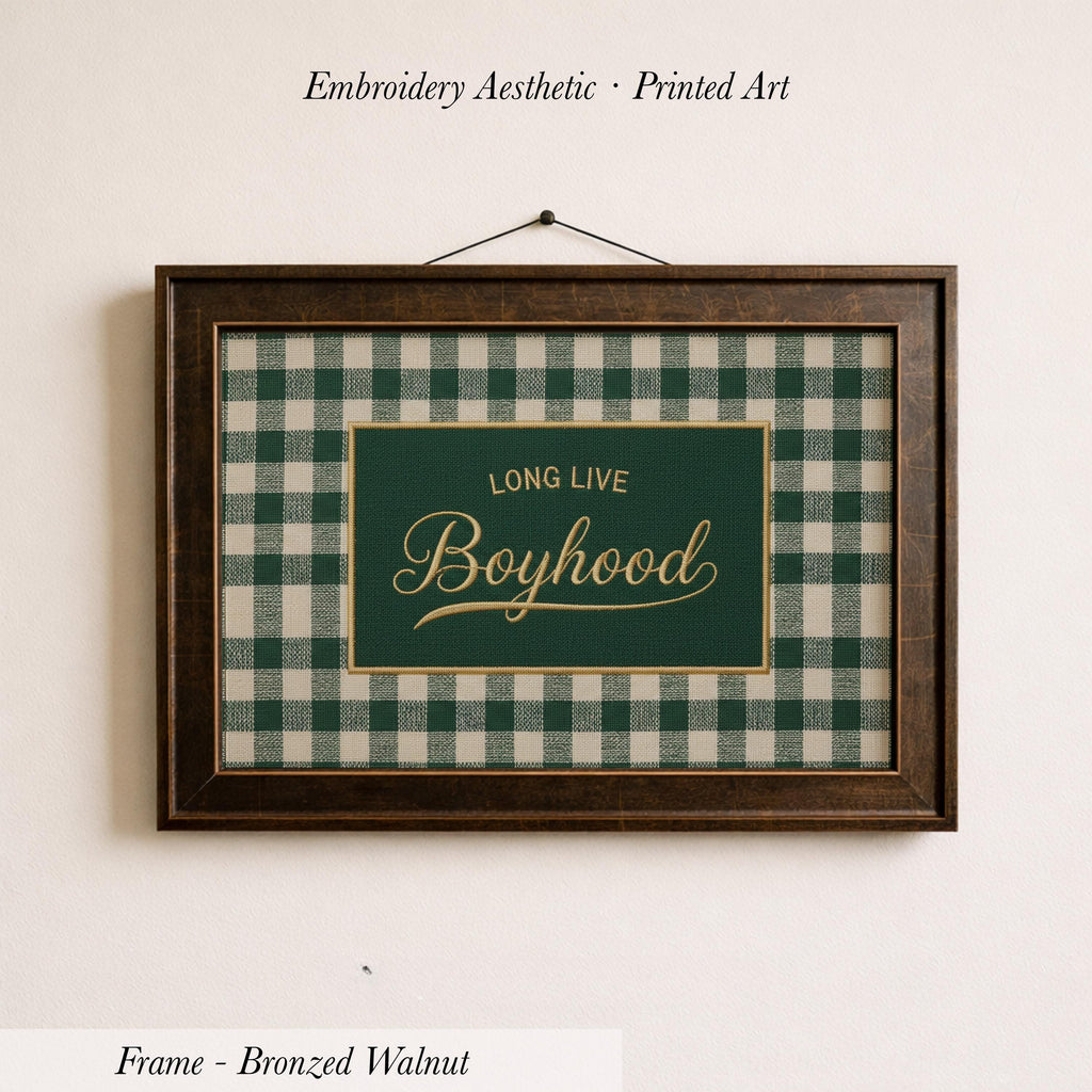 a framed piece of embroidered printed art with a green and white checkered pattern. The text on the frame reads "LONG LIVE BOYHOOD".