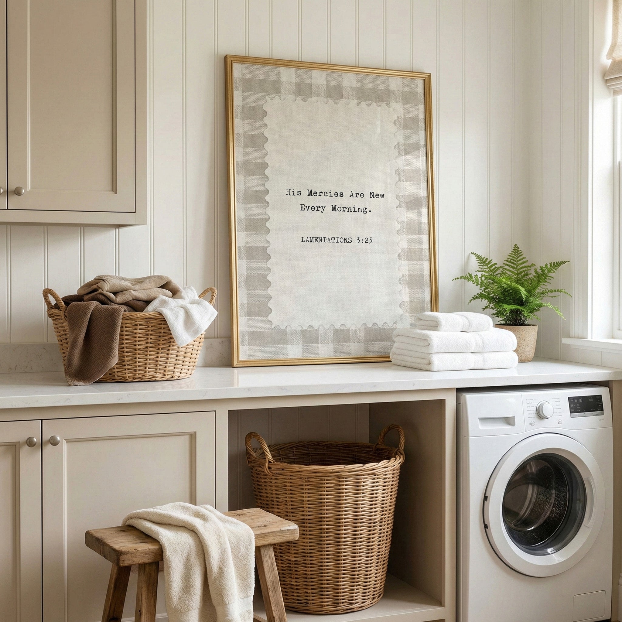A laundry room with a framed quote, baskets of clothes, a washing machine, and a potted plant.