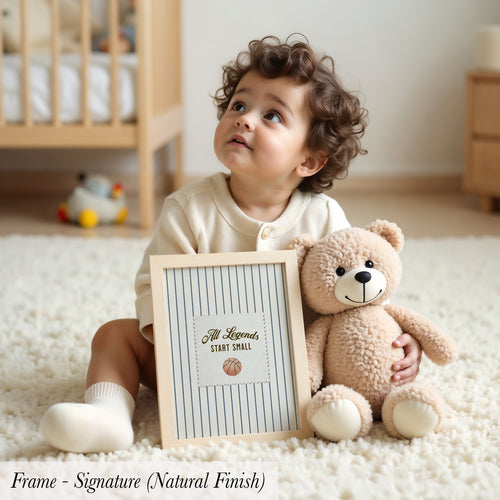 A young child sits on the floor, holding a picture frame with a teddy bear inside.