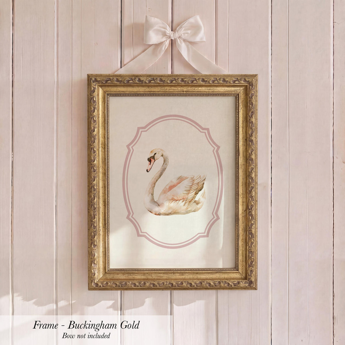 a gold-framed picture of a swan hanging on a wall.