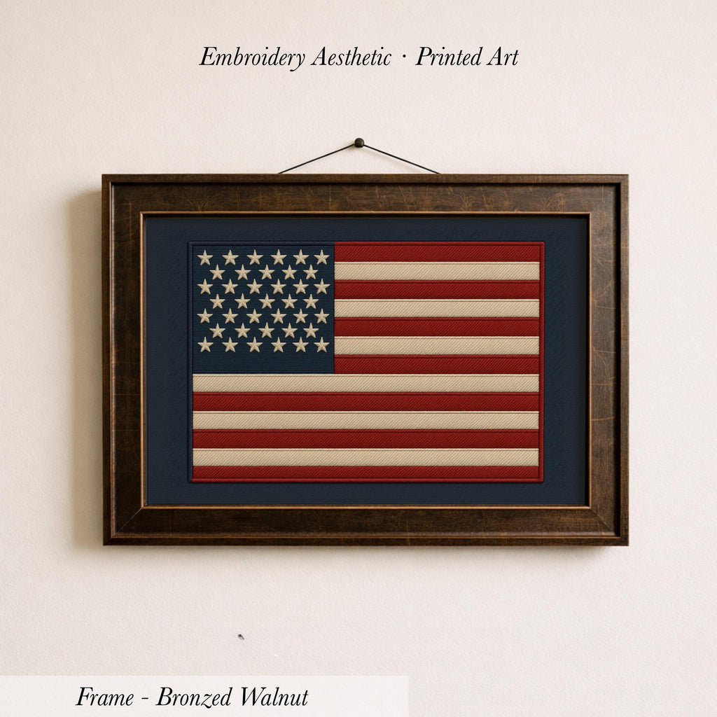 a framed embroidered American flag on a wall.