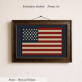 a framed embroidered American flag on a wall.