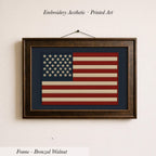 a framed embroidered American flag on a wall.