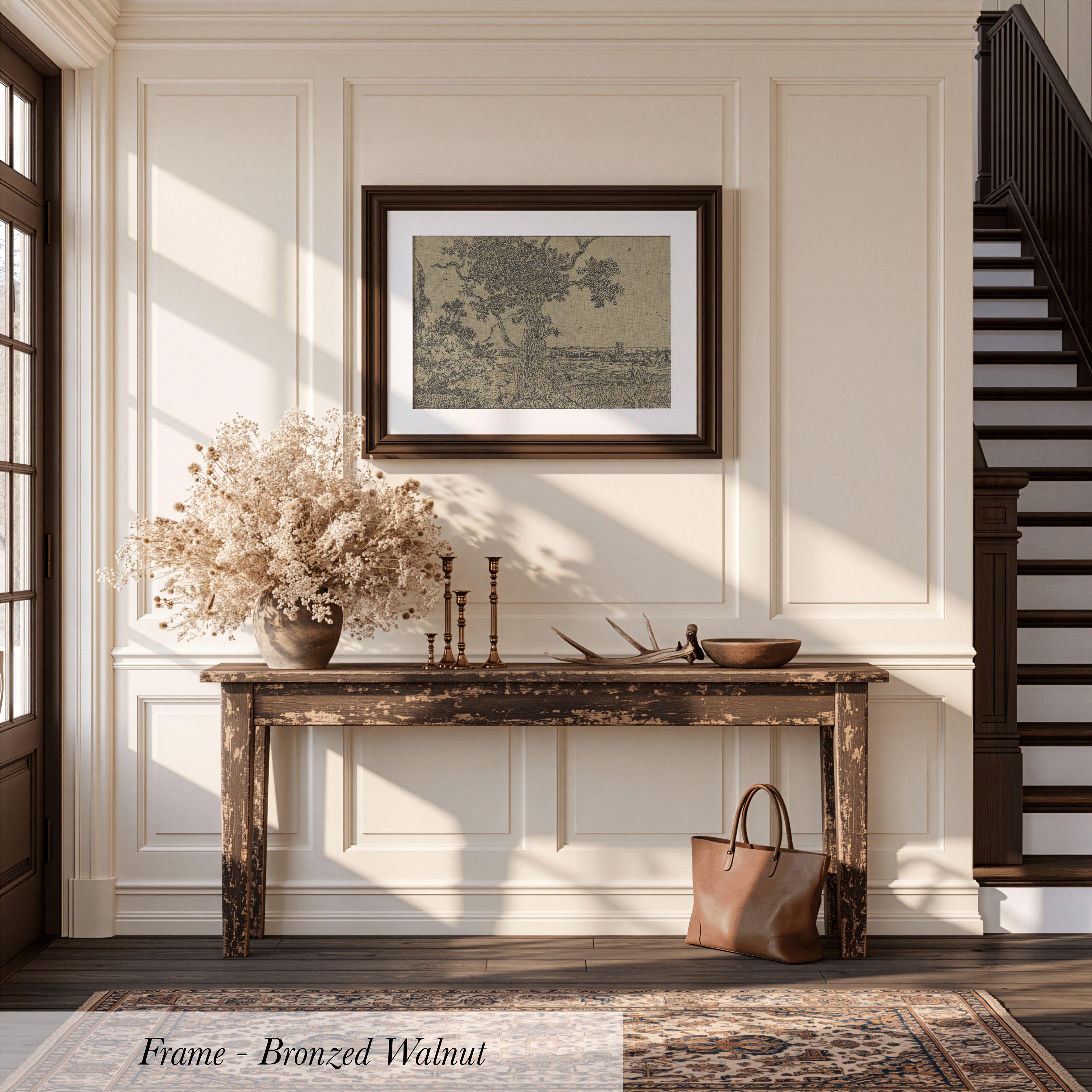 a rustic wooden console table with a vase of dried flowers, a picture frame, and a handbag, set against a white wall and a wooden staircase.