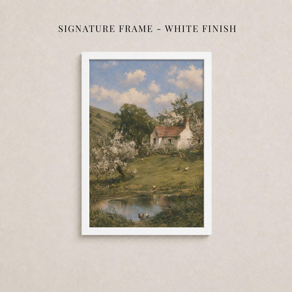 The image is a framed painting depicting a rural landscape with a small white house, a pond, and trees with white flowers.