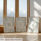 three framed artworks depicting various animals, including elephants, giraffes, and zebras, arranged in a row on a wooden floor.