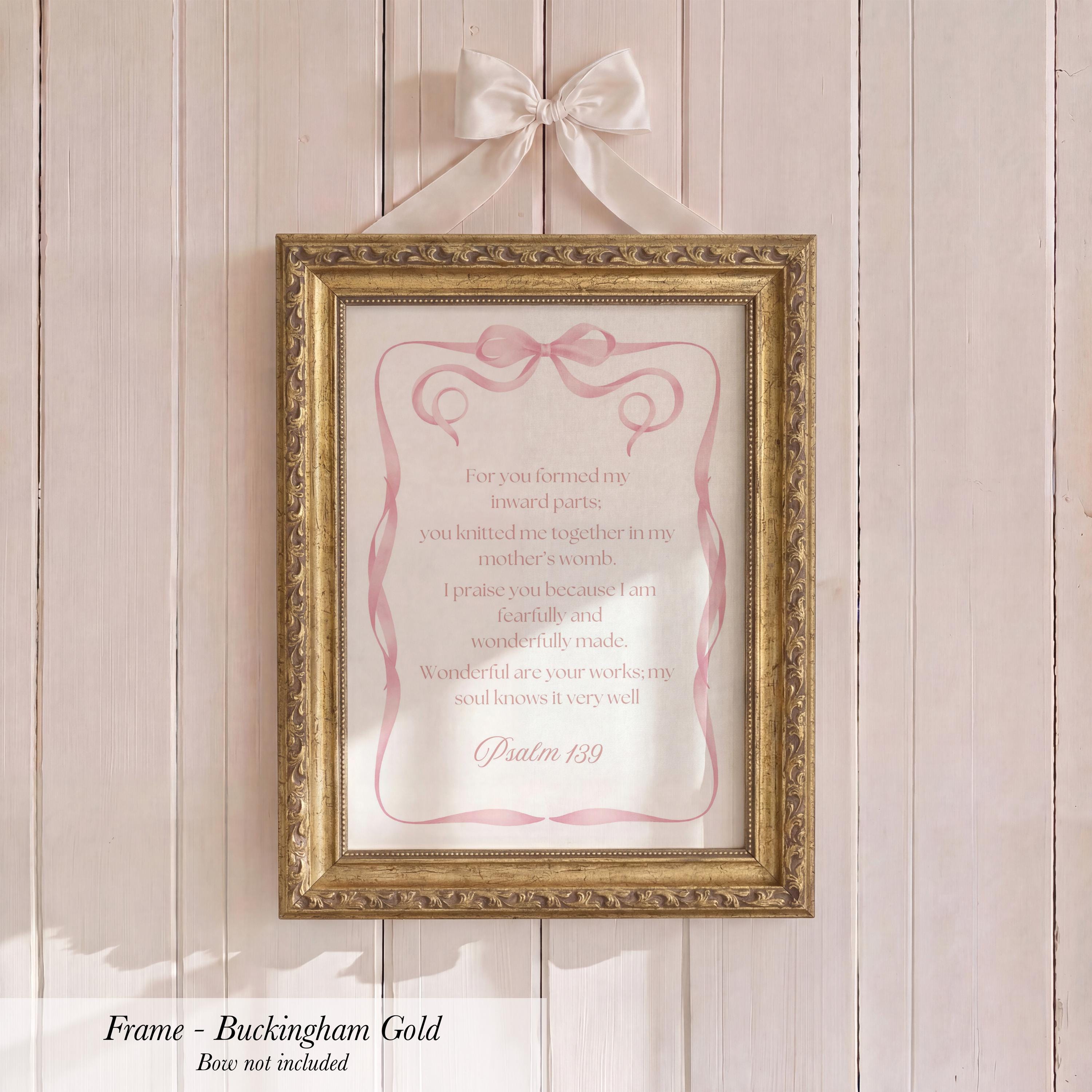 a gold-framed picture hanging on a white wooden wall.