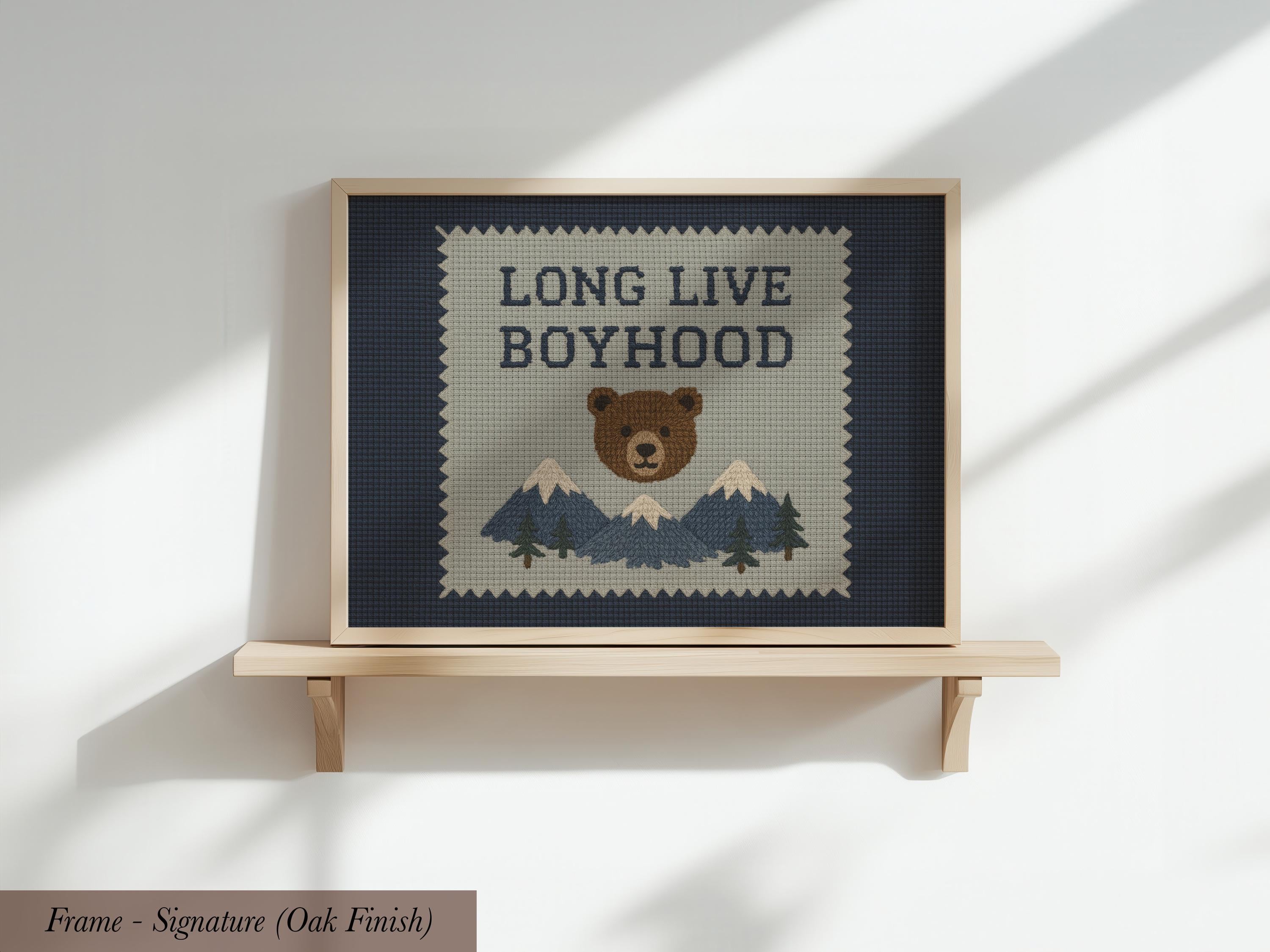 a framed print with a bear and mountains on it, along with the text "LONG LIVE BOYHOOD" displayed prominently.