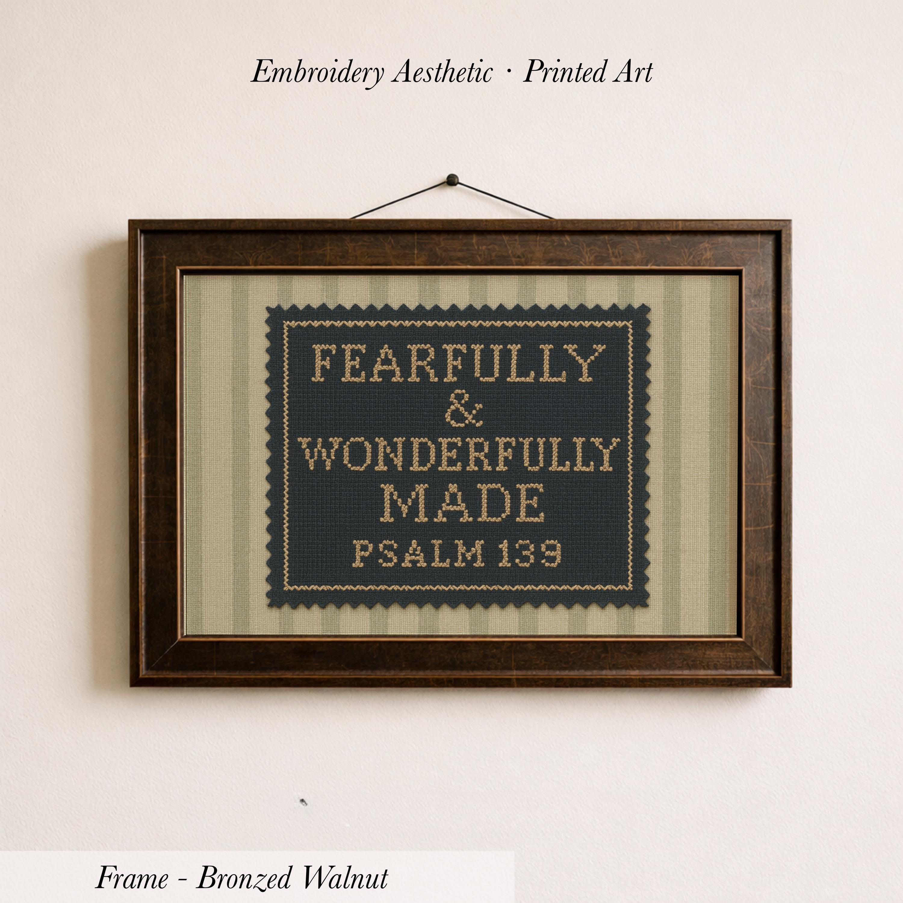 a framed cross-stitch design with the text "FEARFULLY & WONDERFULLY MADE PSALM 139" printed on it.
