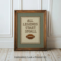 A framed cross-stitch design with the text "ALL LEGENDS START SMALL" and a football image.