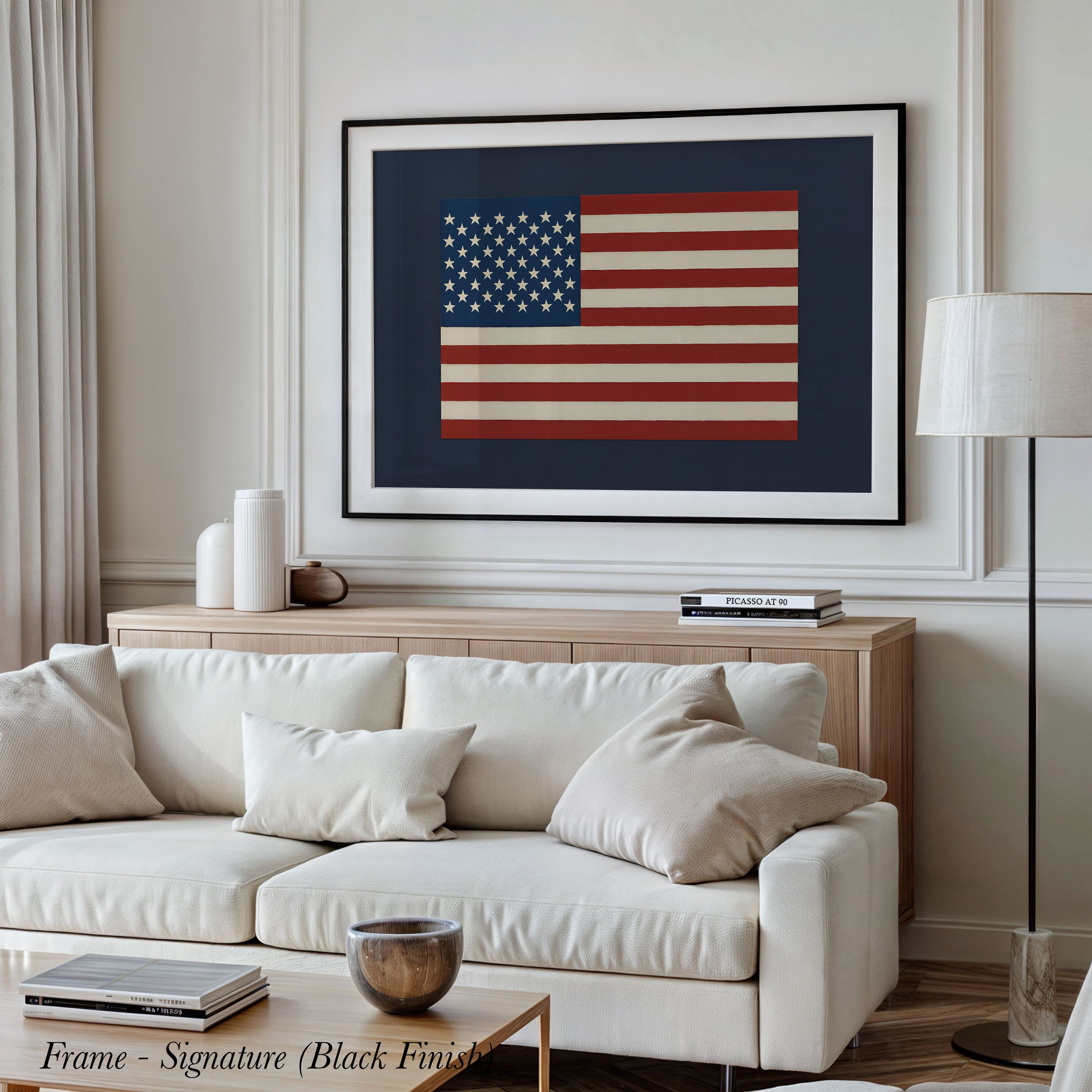 a living room with a large framed picture of the American flag hanging on the wall above a white sofa.