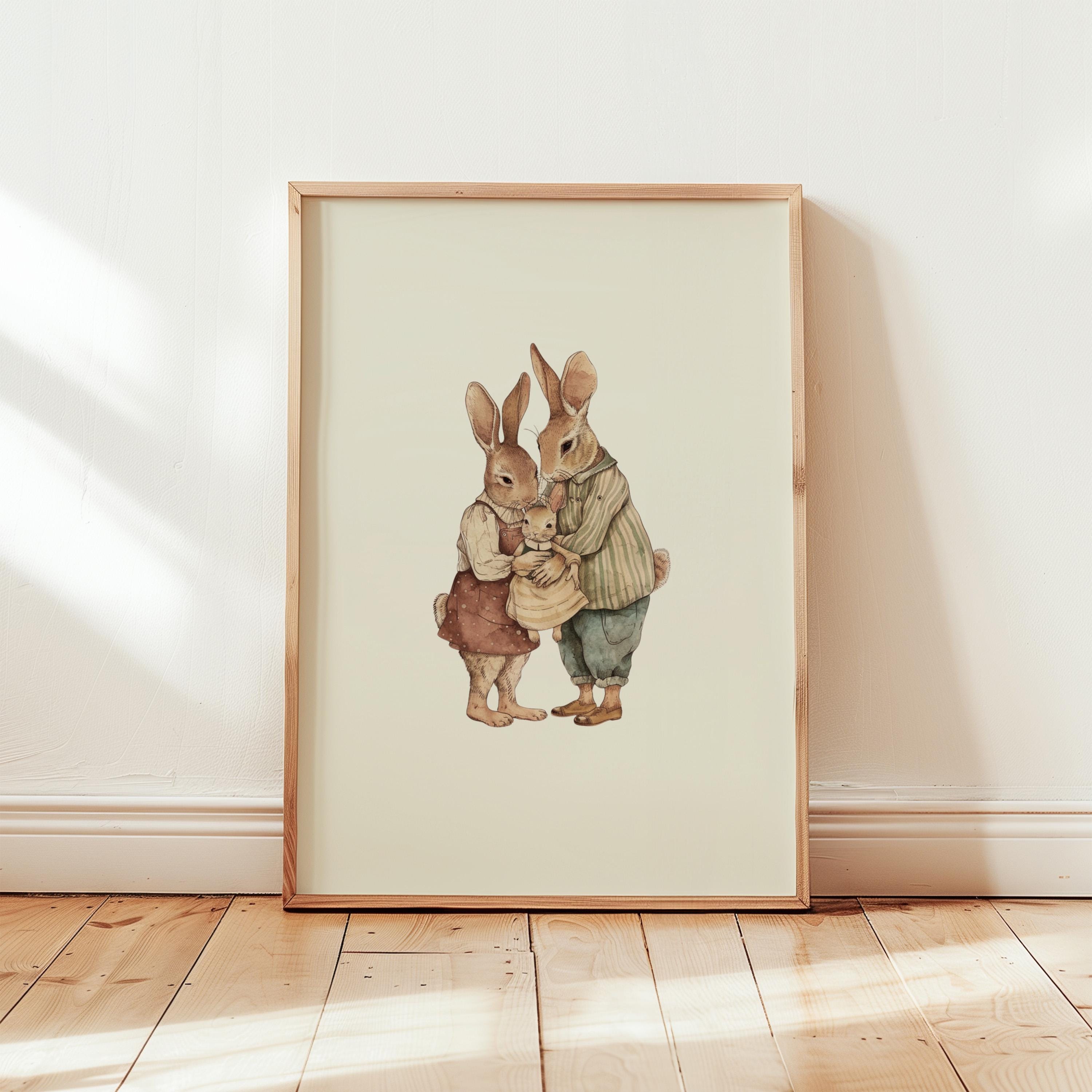 a framed illustration of two rabbits, one wearing a green outfit and the other in a brown outfit, standing together and holding a small object.