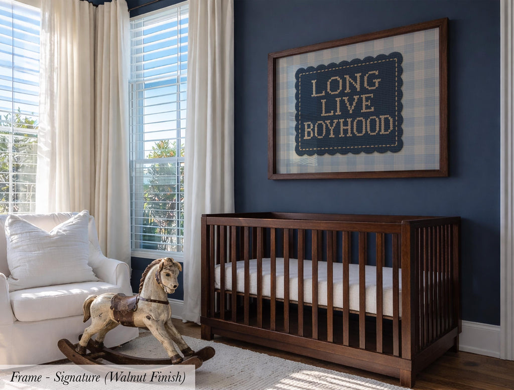 a nursery room with a wooden crib, a rocking horse, and a framed sign on the wall that reads "Long Live Boyhood".