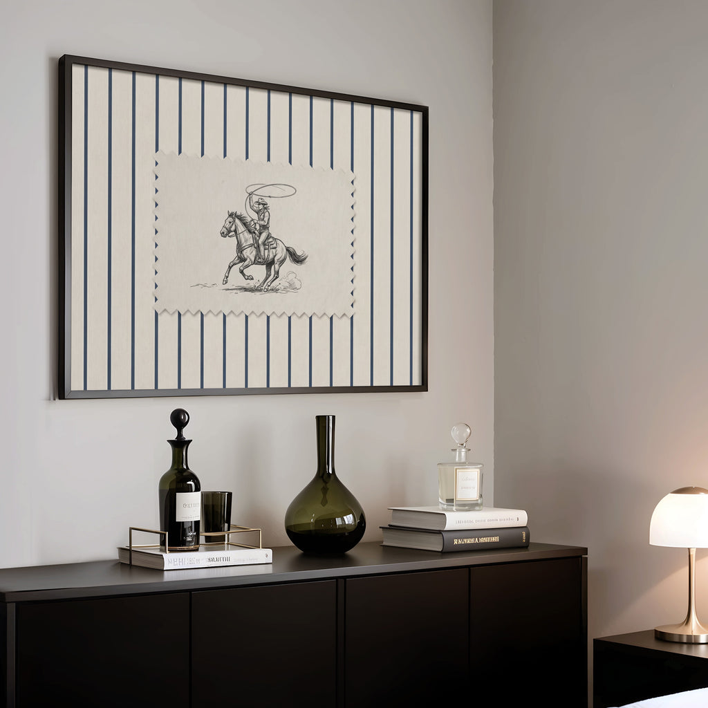 a black and white striped picture frame hanging on a wall above a black cabinet with various items on top, including a bottle, a vase, and a stack of books.