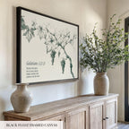 a black-framed canvas hanging on a wall, depicting a vine with grapes. Below the canvas, there are two vases on a wooden cabinet, and a potted plant on a shelf.