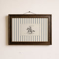 a framed picture of a cowboy riding a horse, with a black and white illustration of the cowboy and the horse.
