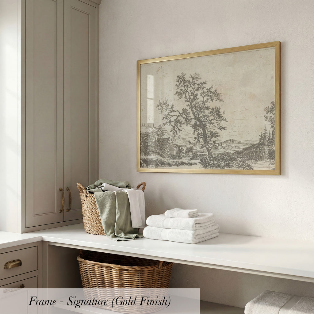 a white counter with a wicker basket filled with folded towels, a framed landscape drawing hanging on the wall, and a wooden cabinet below the counter.