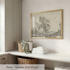 a white counter with a wicker basket filled with folded towels, a framed landscape drawing hanging on the wall, and a wooden cabinet below the counter.