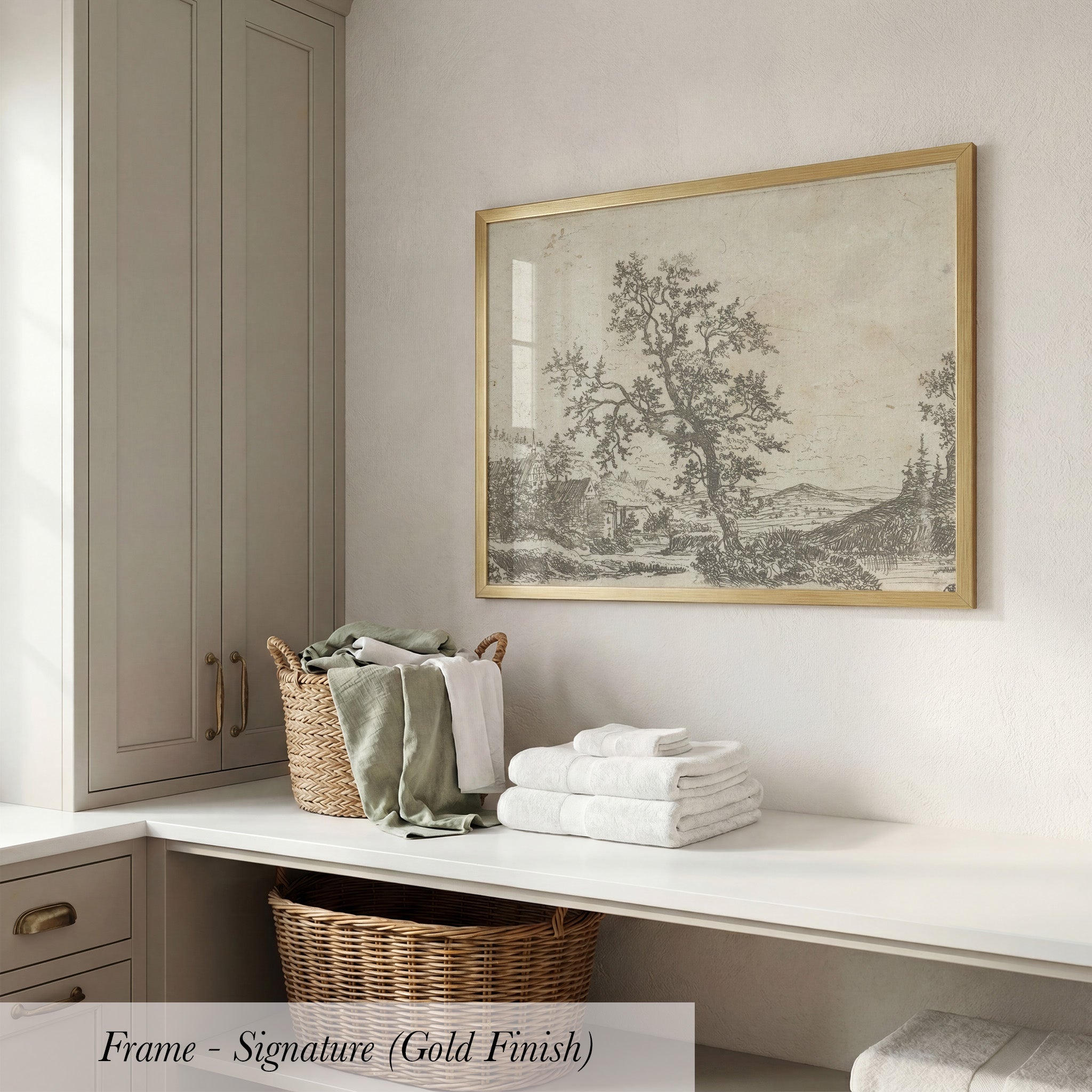 a white counter with a wicker basket filled with folded towels, a framed landscape drawing hanging on the wall, and a wooden cabinet below the counter.
