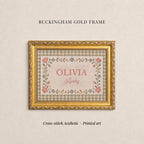 The image is a gold-framed cross-stitch print titled "OLIVIA Avery" with a floral border. The text "BUCKHAM GOLD FRAME" is displayed above the print, and the phrase "Cross-stitch Aesthetic - Printed art" is at the bottom of the image.