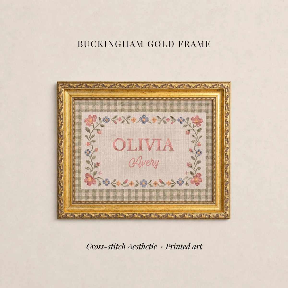 The image is a gold-framed cross-stitch print titled "OLIVIA Avery" with a floral border. The text "BUCKHAM GOLD FRAME" is displayed above the print, and the phrase "Cross-stitch Aesthetic - Printed art" is at the bottom of the image.