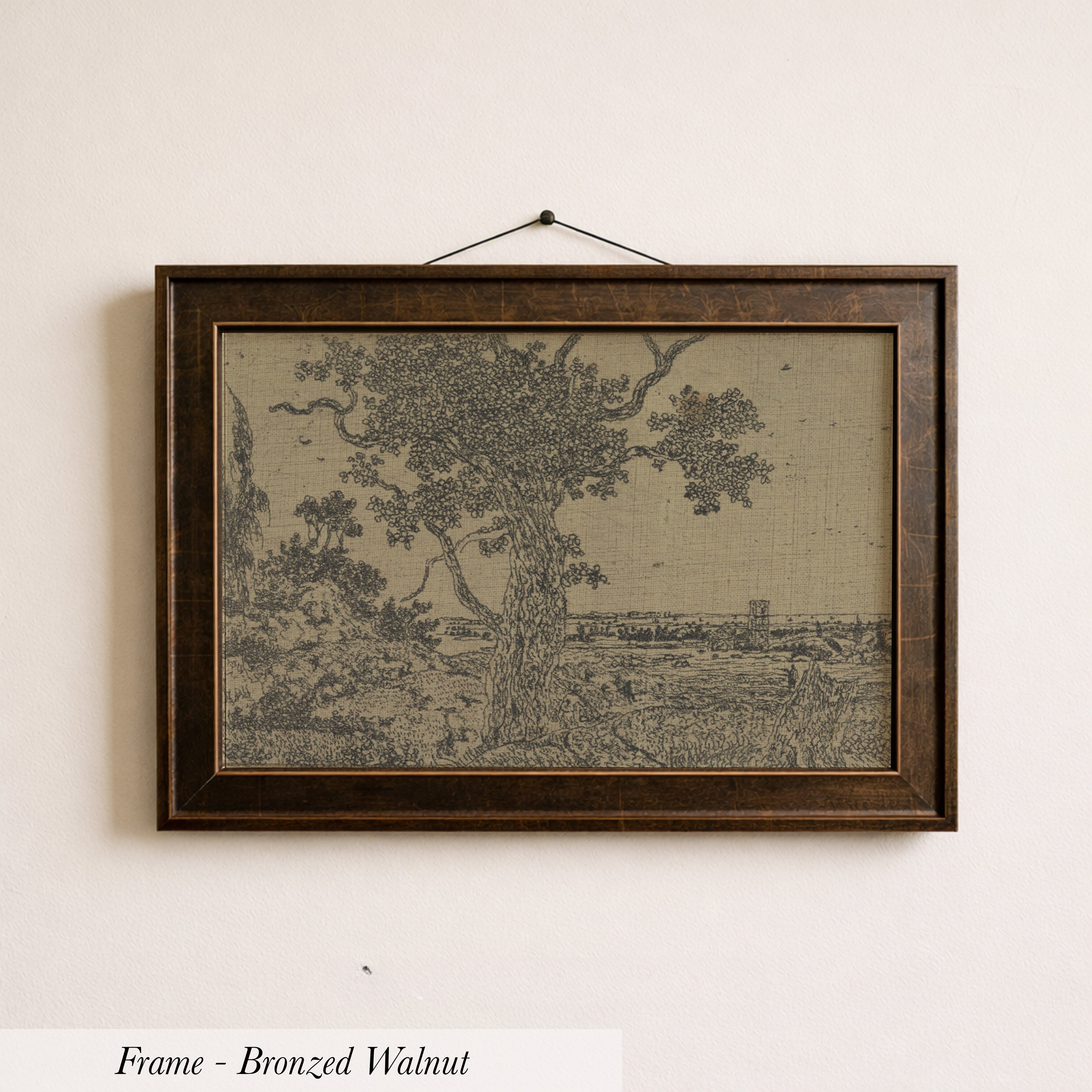 The image is a framed bronze-colored painting depicting a tree and a landscape scene.