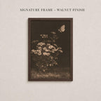 The image is a framed photograph of a flower arrangement with a butterfly in flight.