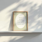 A framed poster with the text "YOU'LL NEVER KNOW DEAR HOW MUCH I LOVE YOU" is displayed on a white shelf against a white wall.