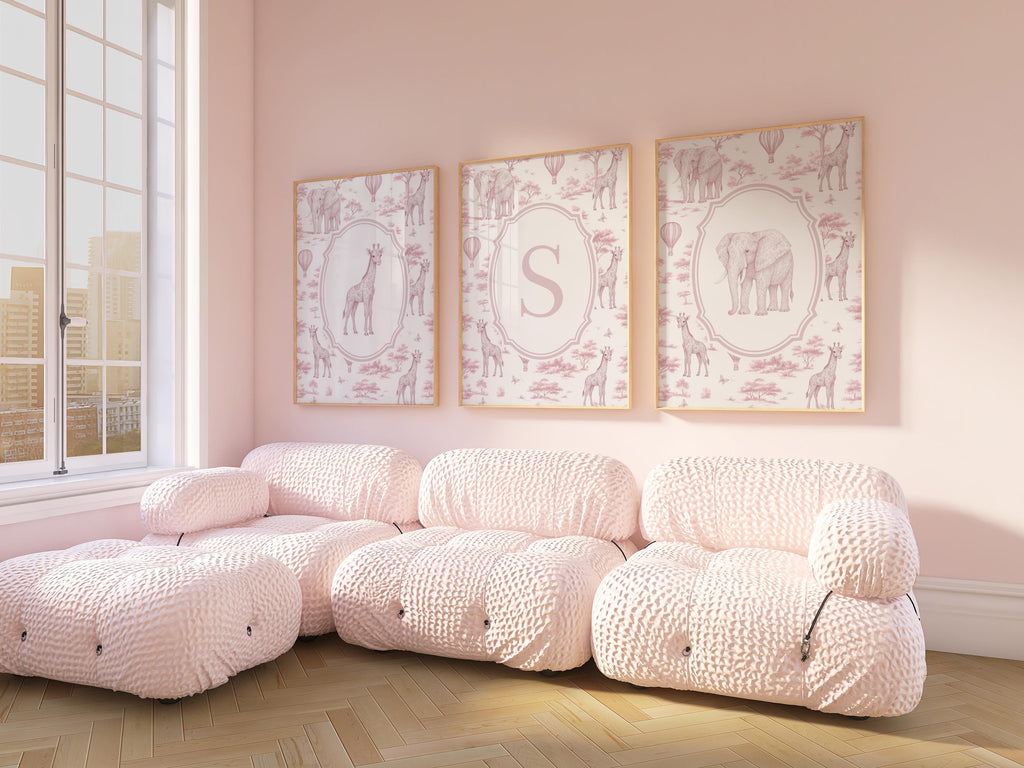 A cozy living room with a large window, featuring three framed pictures of giraffes on the wall. The room has a plush, pink-colored sofa and a matching ottoman, creating a warm and inviting atmosphere.