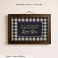 a framed print with the text "You'll never know how much I love you" on it, hanging on a wall.