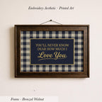 a framed print with the text "You'll never know how much I love you" on it, hanging on a wall.